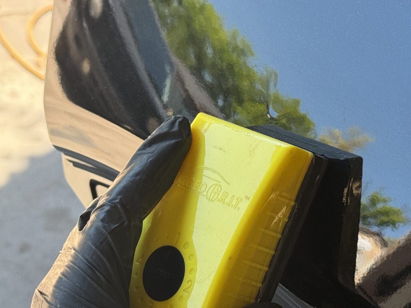 Here's an alt tag for the image: Gloved hand using a detailing tool.