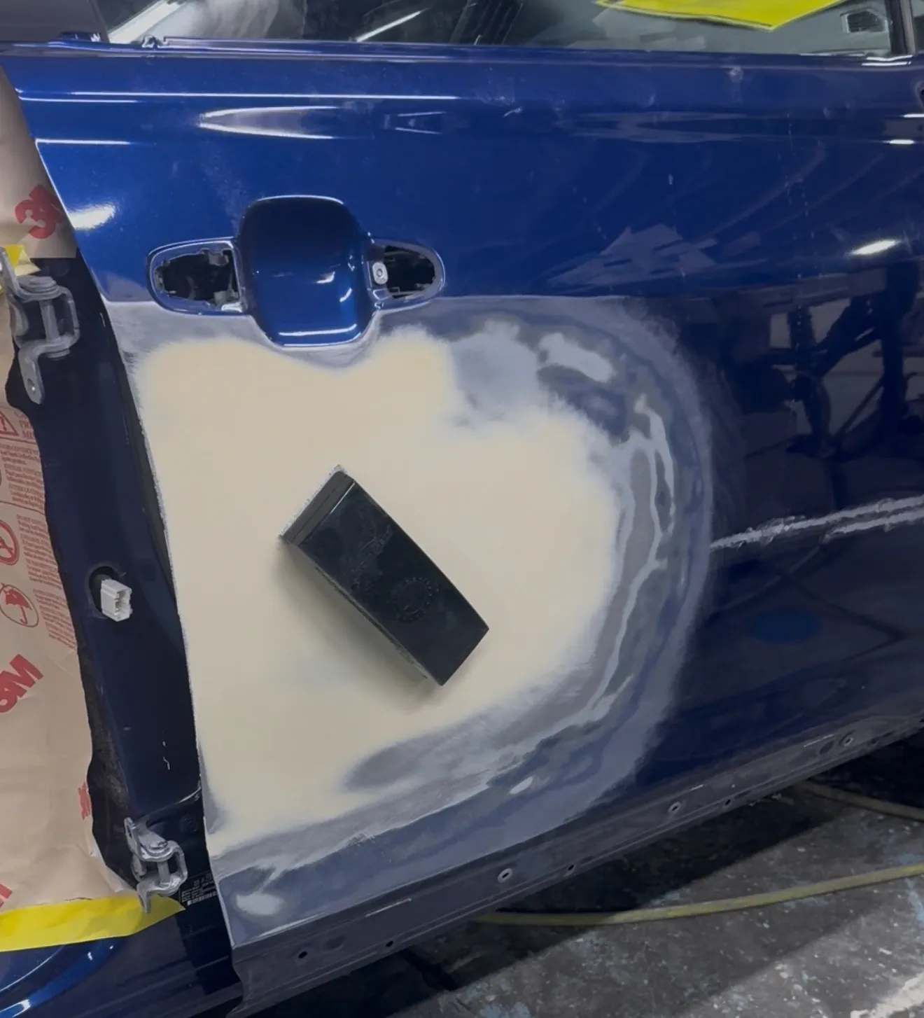 Car door being repaired with sanding in progress.